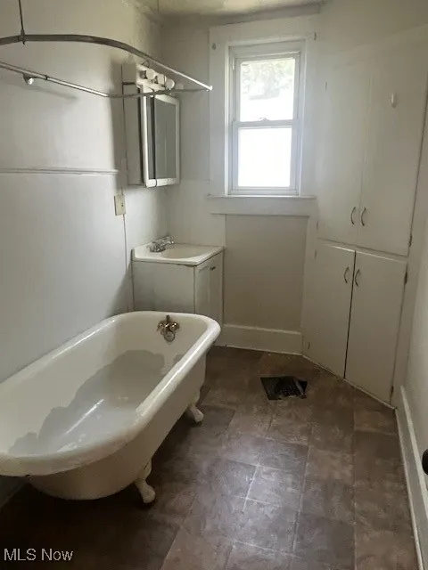 Full bath with a soaking tub and stone finish floors