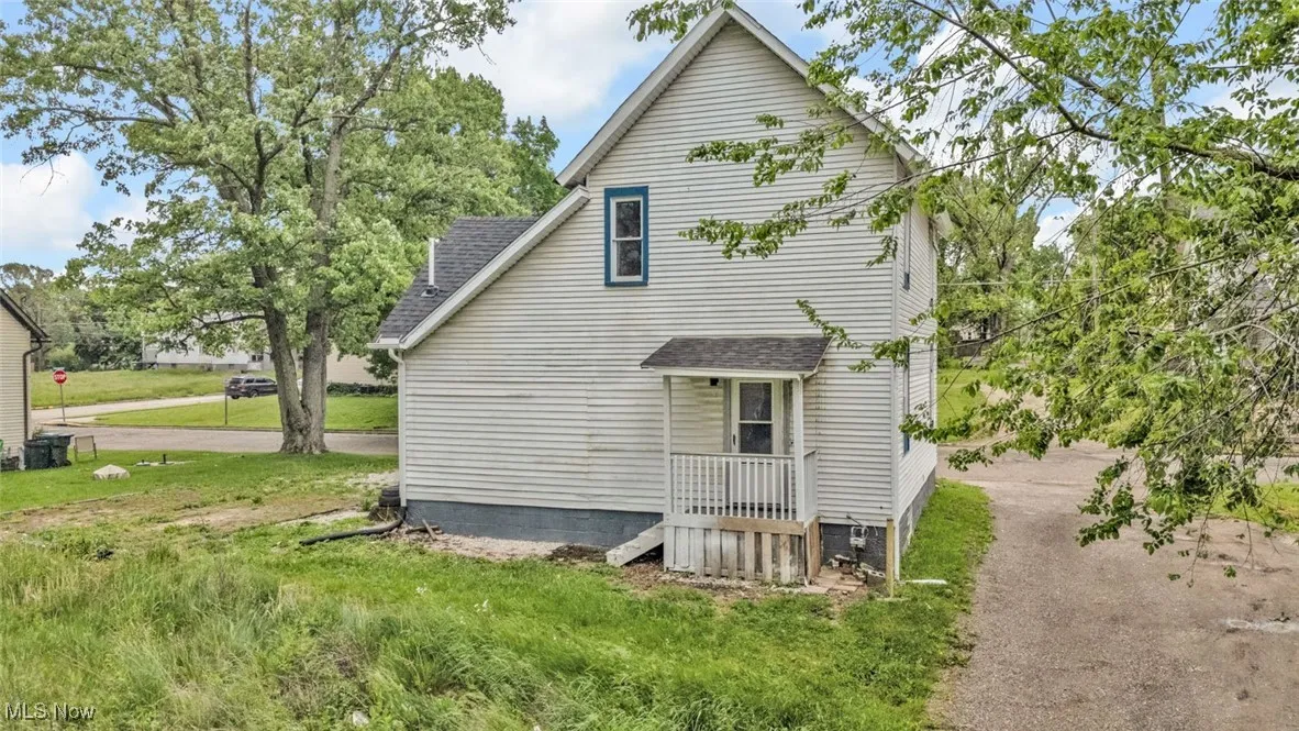 View of side of property with a shingled roof