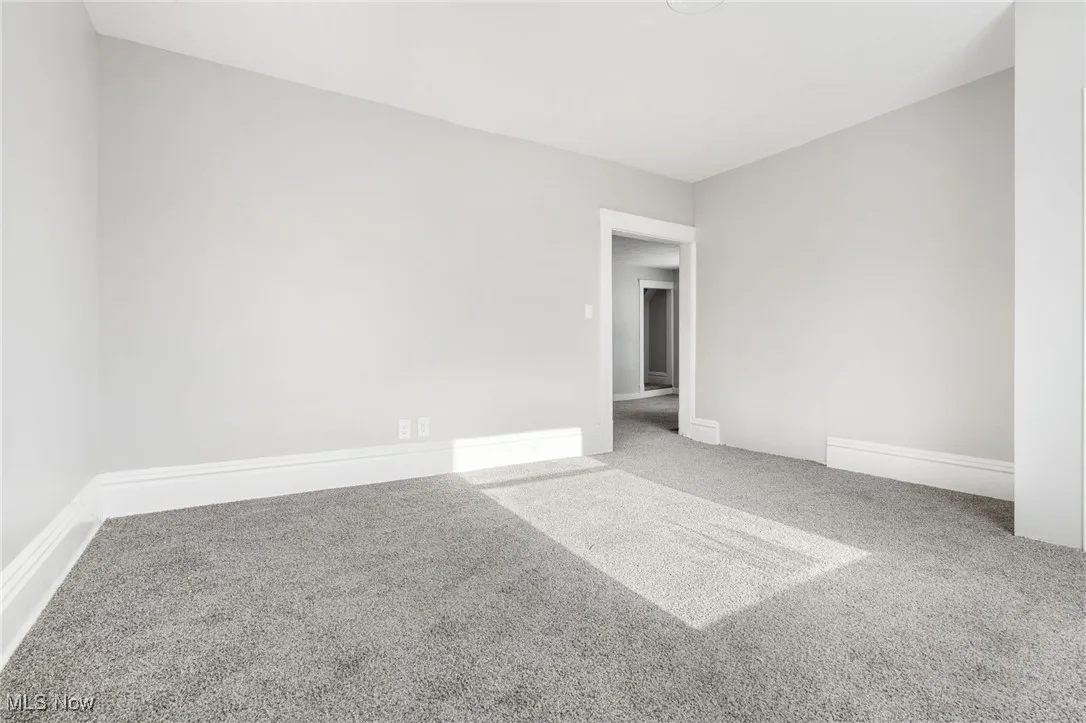 Empty room featuring carpet flooring and baseboards