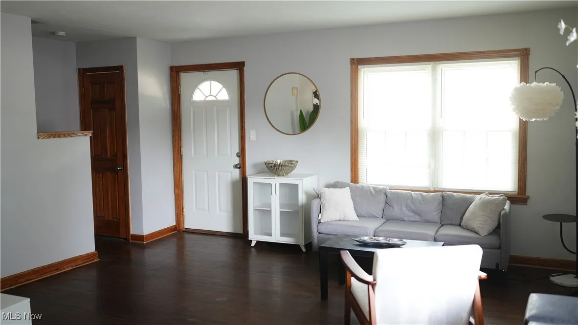 Living room with baseboards and dark wood-style flooring