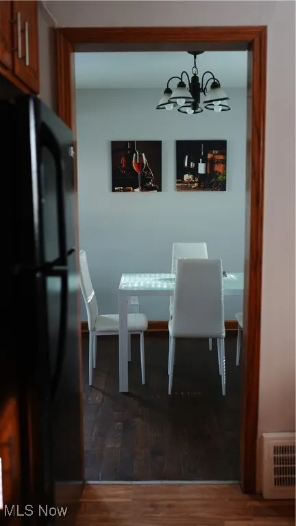 Dining area with wood finished floors and a chandelier