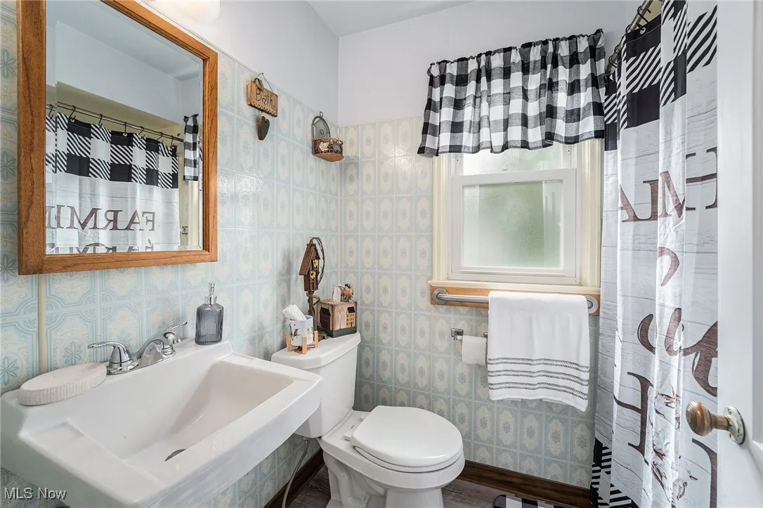 Bathroom with a sink, toilet, and a shower with curtain