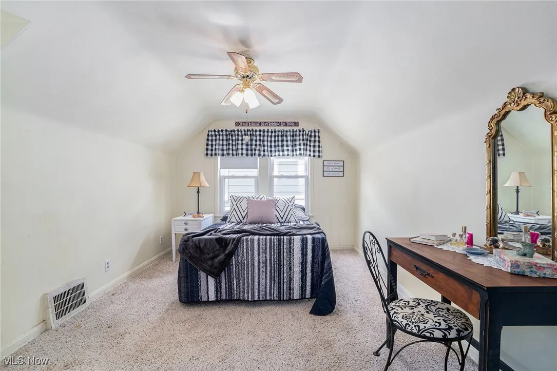 Bedroom featuring lofted ceiling, carpet, a ceiling fan, and baseboards