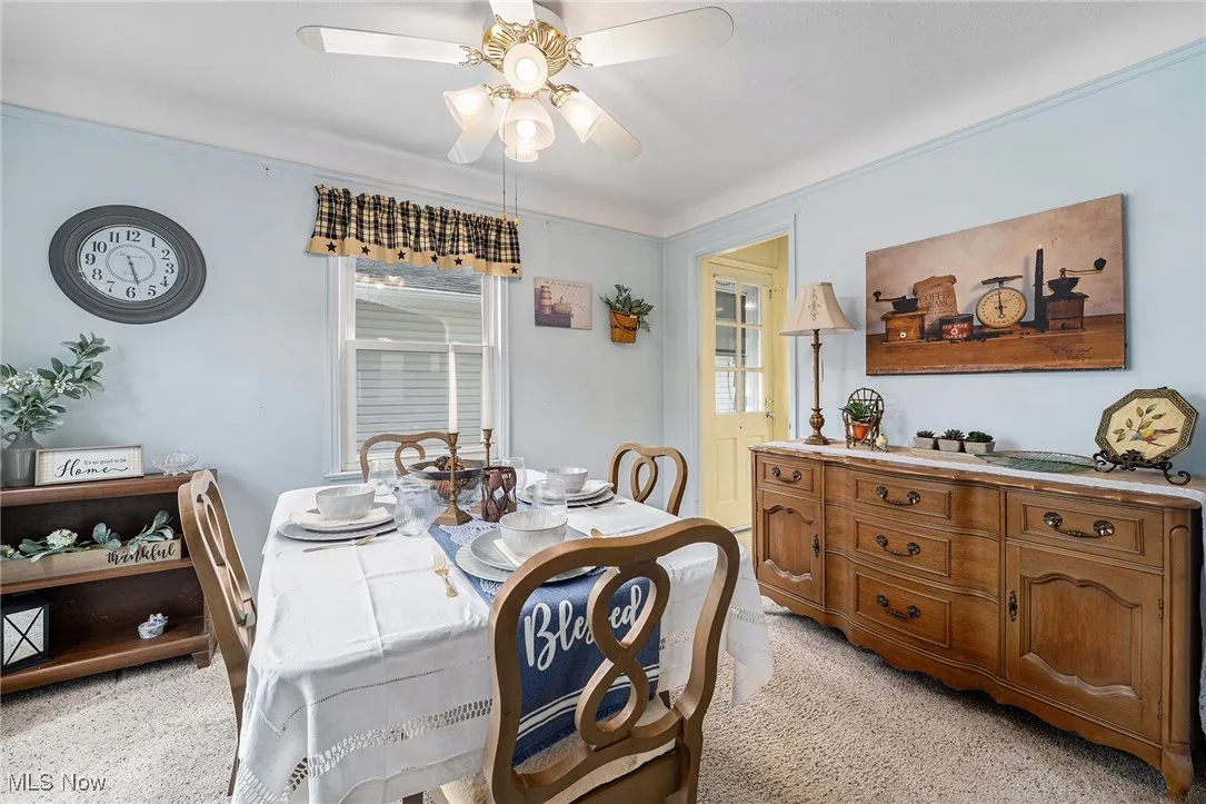 Dining space featuring light colored carpet and ceiling fan