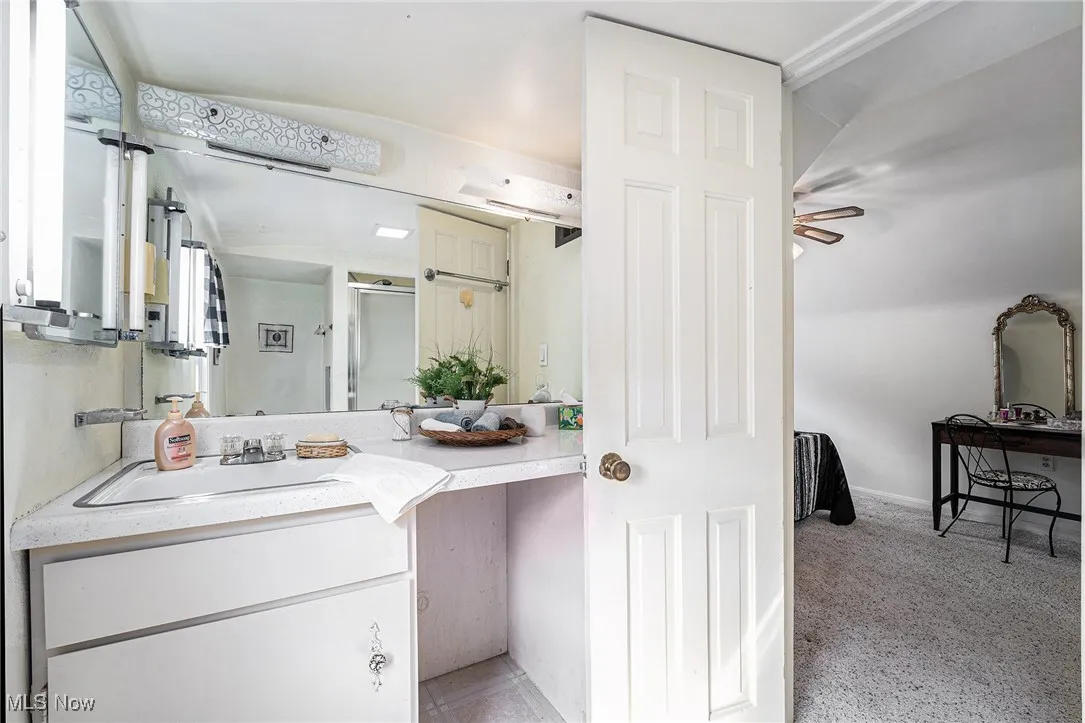 Full bath with vanity and a shower with door