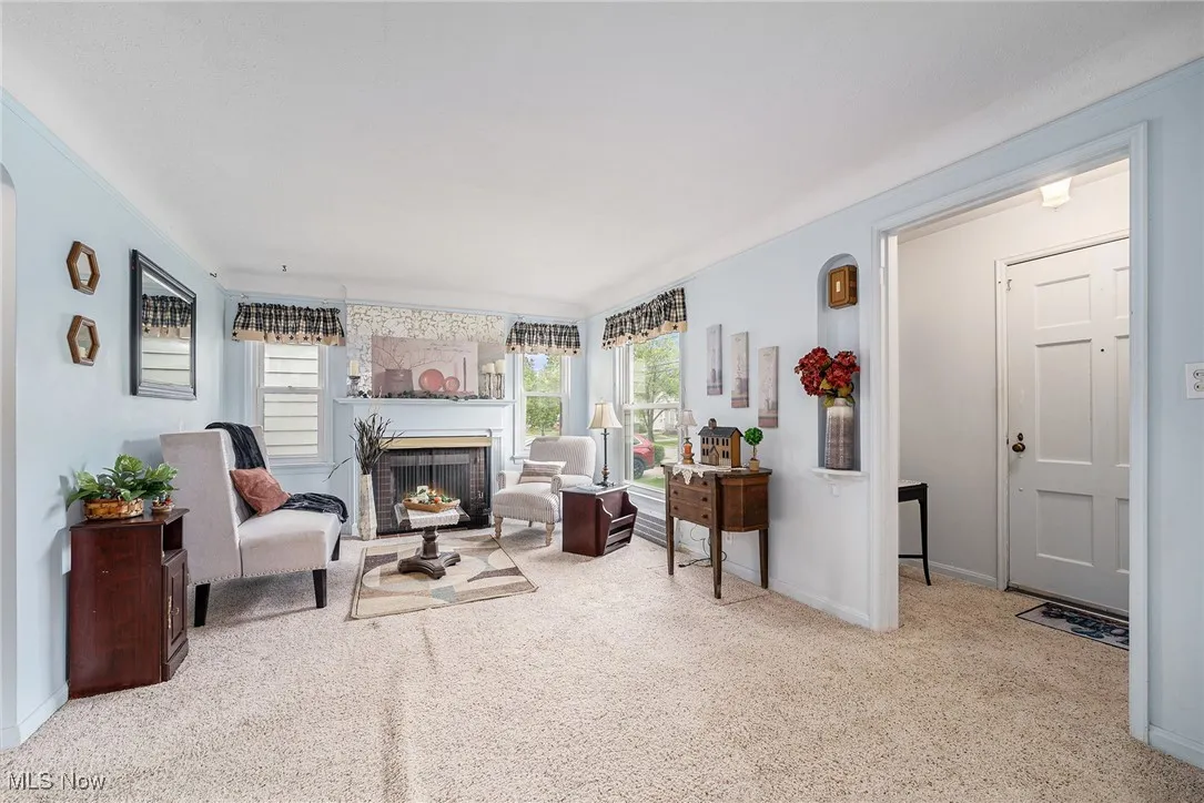 Living area with carpet, a fireplace, and baseboards