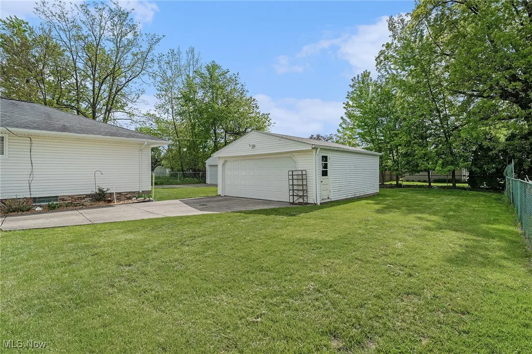 View of yard featuring a detached garage and an outbuilding