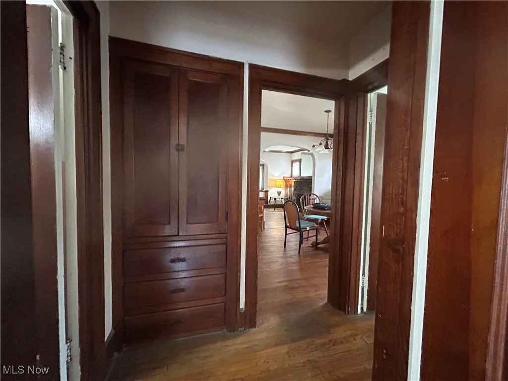 Hallway featuring wood finished floors and built ins.