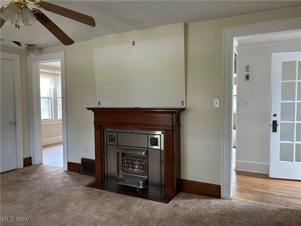 Second Floor Apartment living room with carpet flooring, ceiling fan, a fireplace with flush hearth, and baseboards