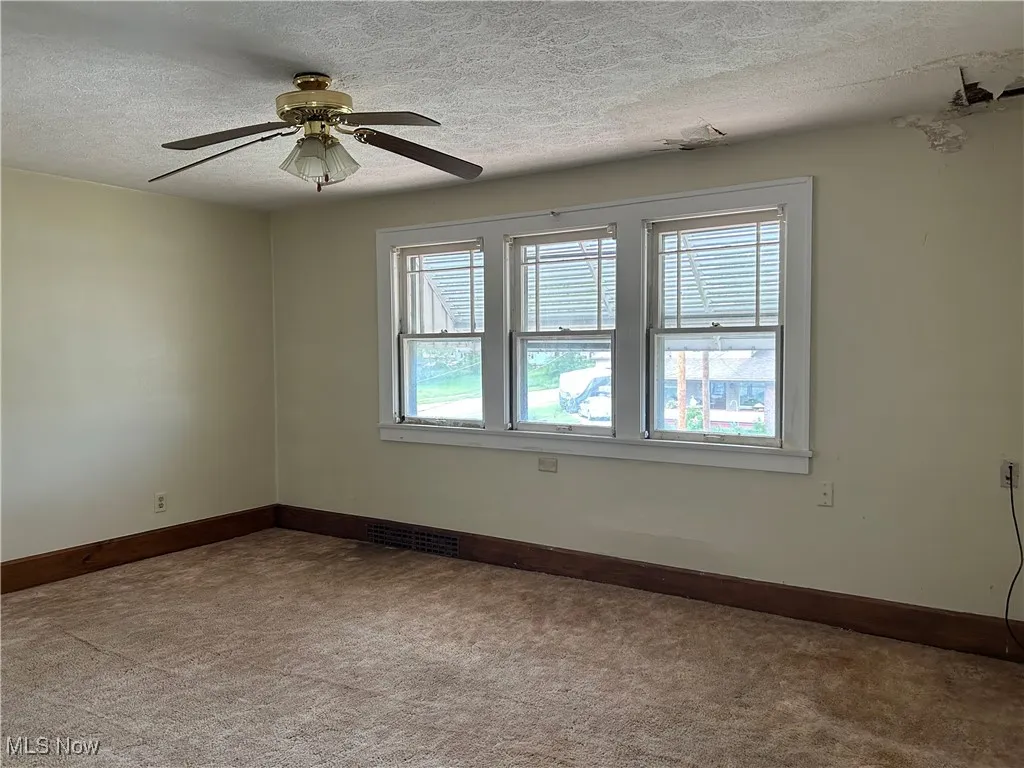  featuring carpet flooring, baseboards, a textured ceiling, and a ceiling fan