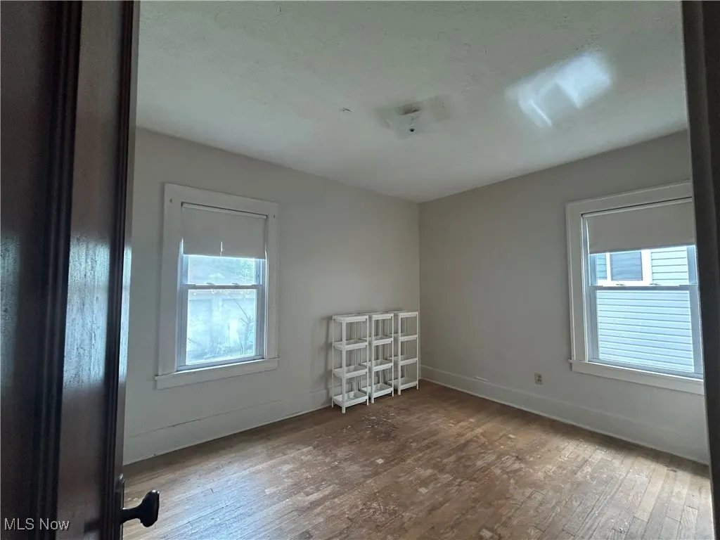 First floor bedroom featuring wood finished floors and baseboards
