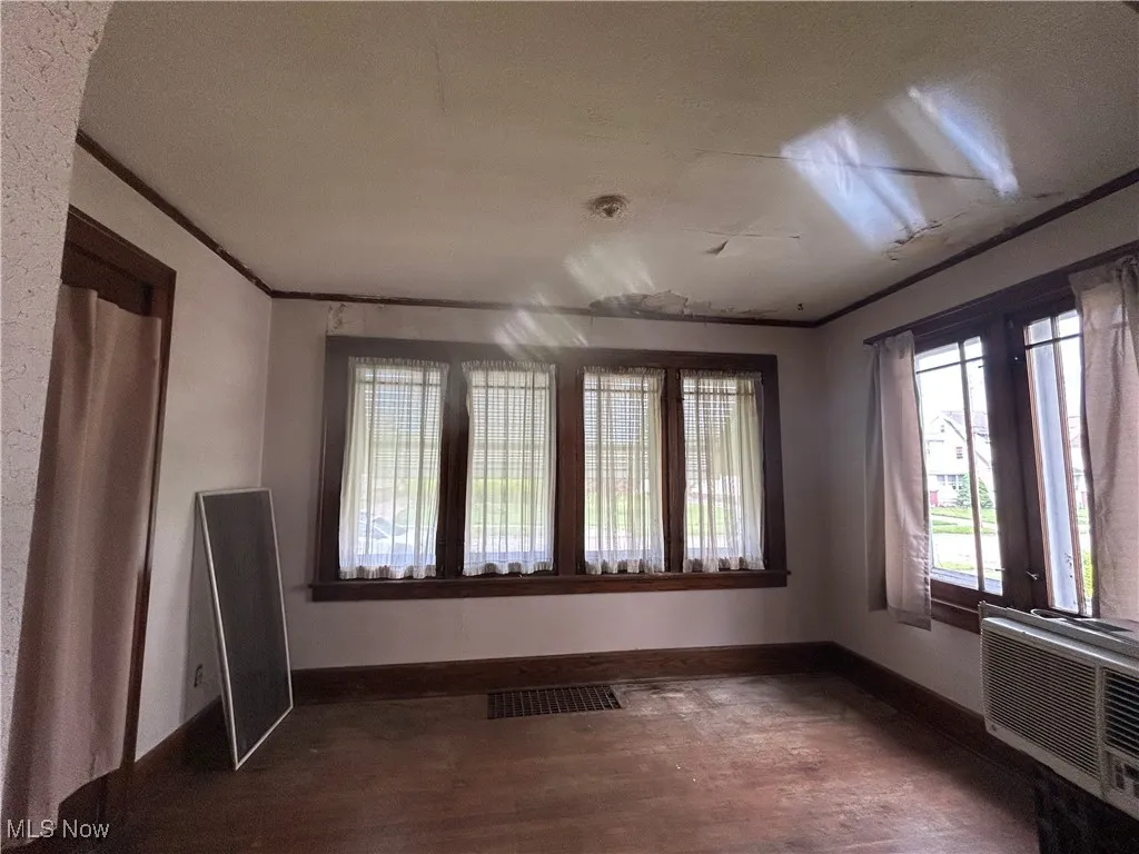  Entry to first floor apartment featuring plenty of windows, baseboards, and wood floors.