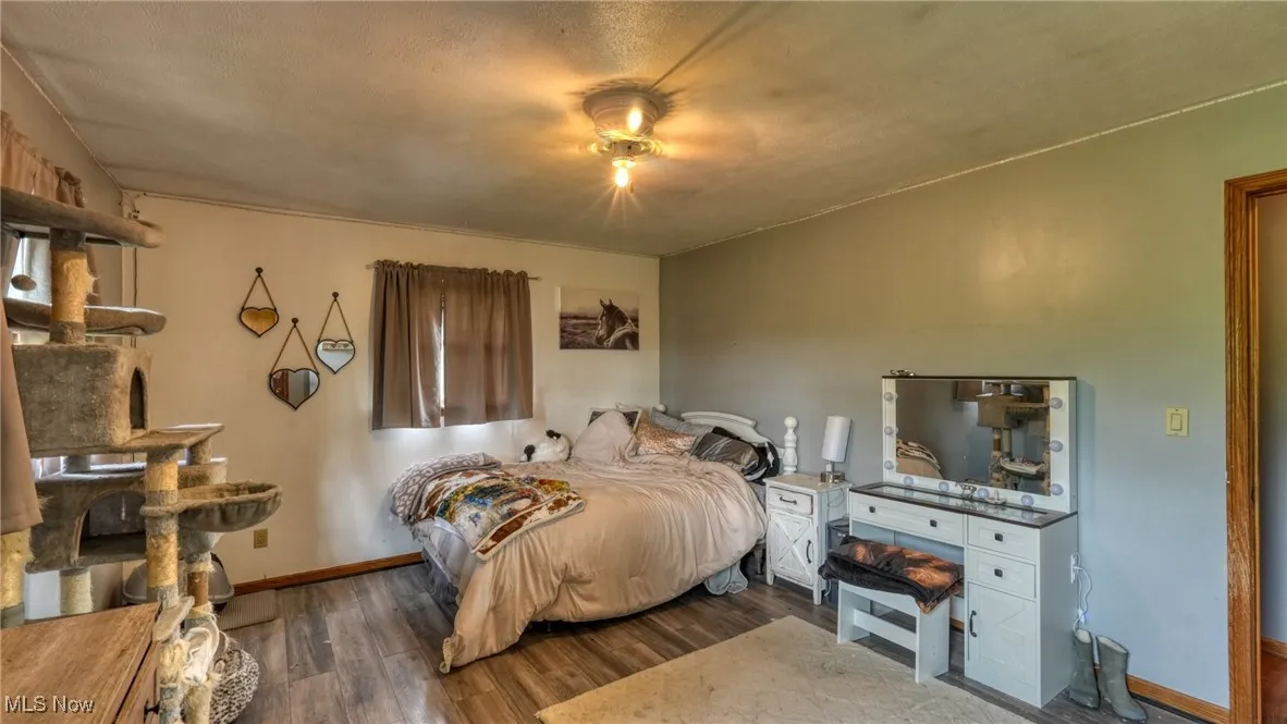 Bedroom featuring wood finished floors and baseboards