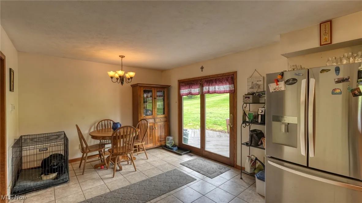 Dining area featuring tile patterned flooring, a chandelier, and baseboards