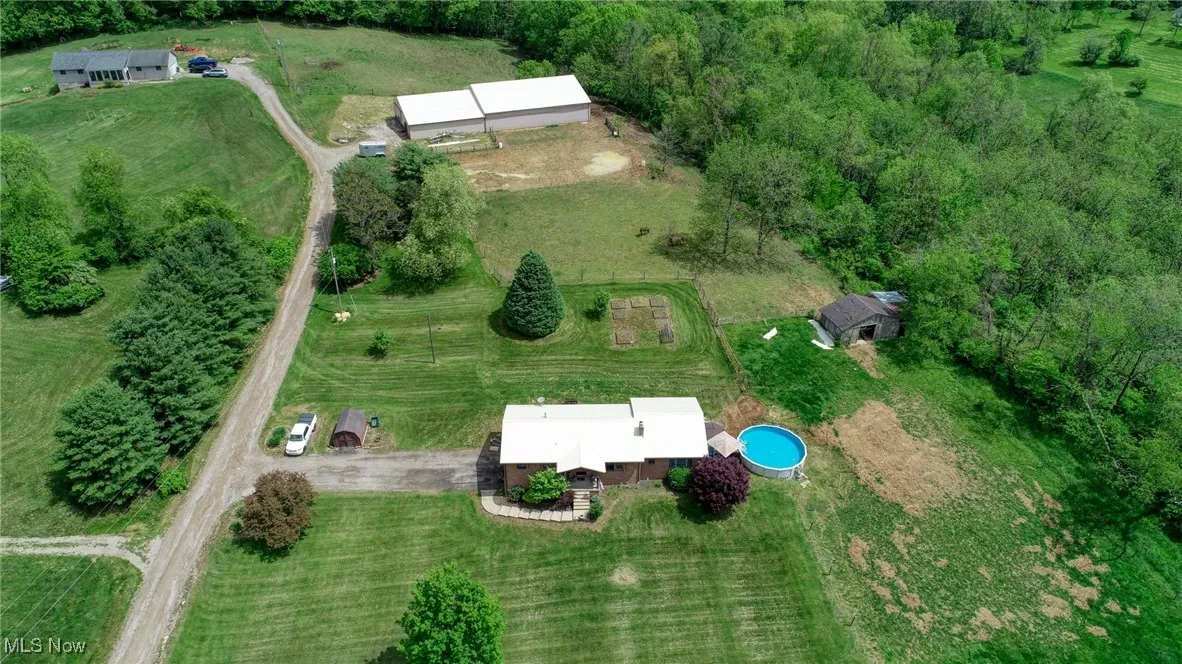 Aerial view of property's location featuring rural landscape and a pool area