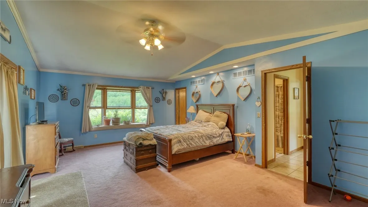 Bedroom with lofted ceiling, carpet, baseboards, and ceiling fan