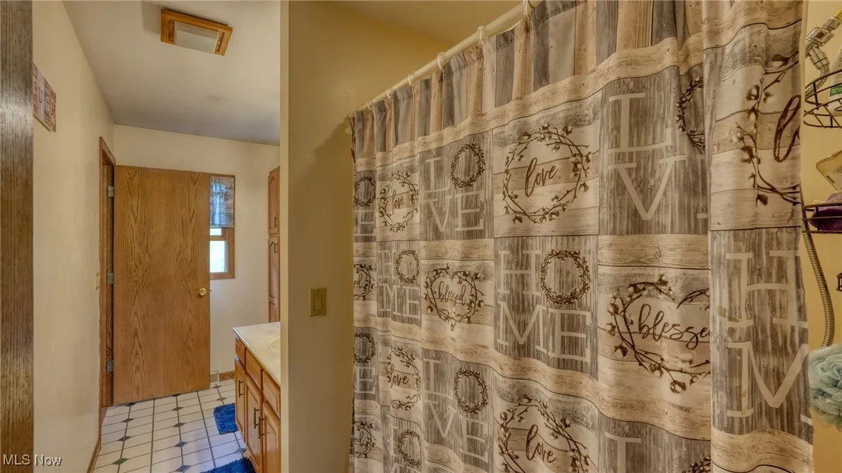 Full bath with curtained shower and vanity