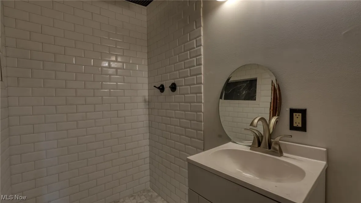 Bathroom with a tile shower and vanity