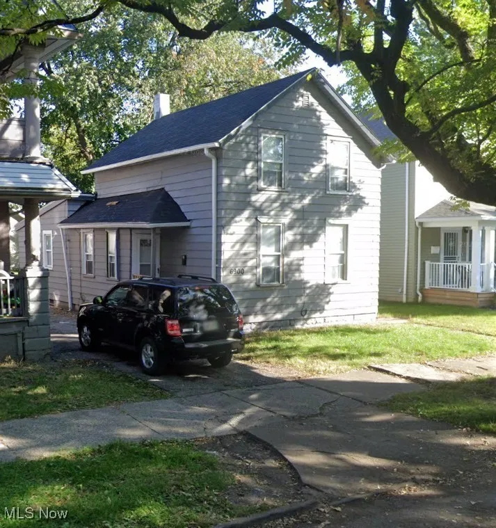 View of front of home with a chimney and driveway