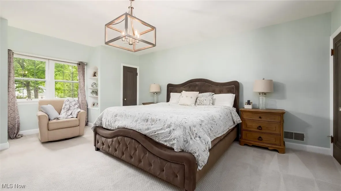 Bedroom featuring a chandelier, baseboards, and carpet floors