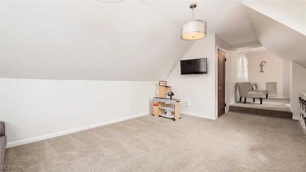 Additional living space featuring carpet floors, lofted ceiling, and baseboards