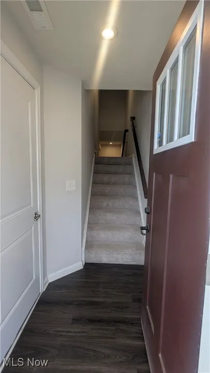 Stairs featuring wood finished floors and baseboards