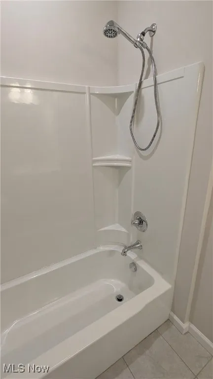 Full bathroom featuring tile patterned floors, shower / bath combination, and baseboards