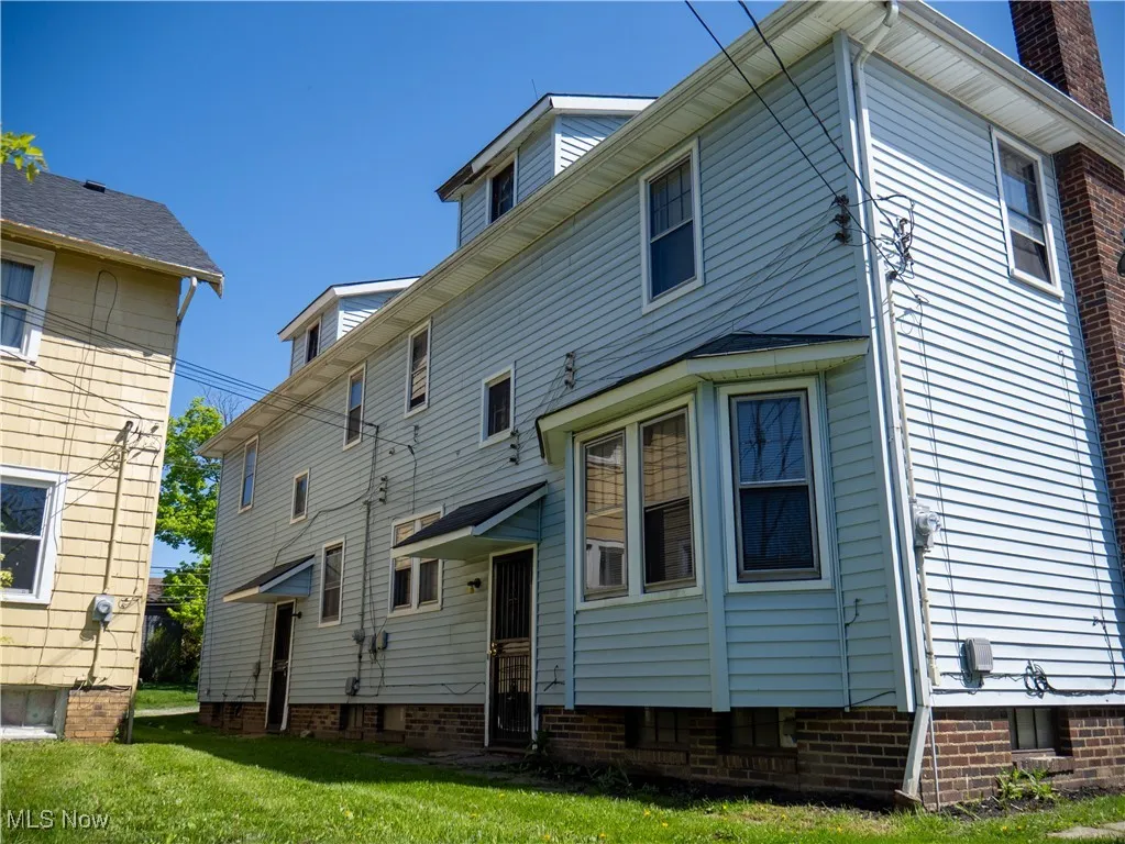 Back of property with a lawn, entry steps, and a chimney
