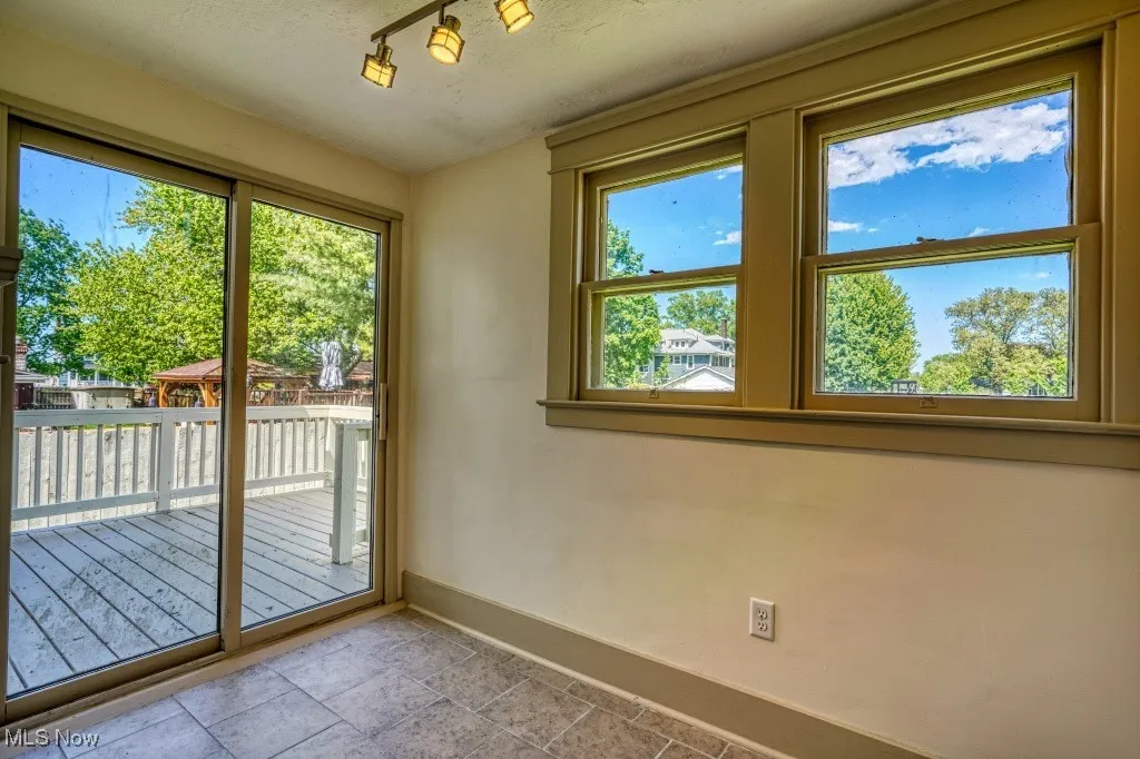 Doorway with baseboards, stone finish flooring, and a textured ceiling
