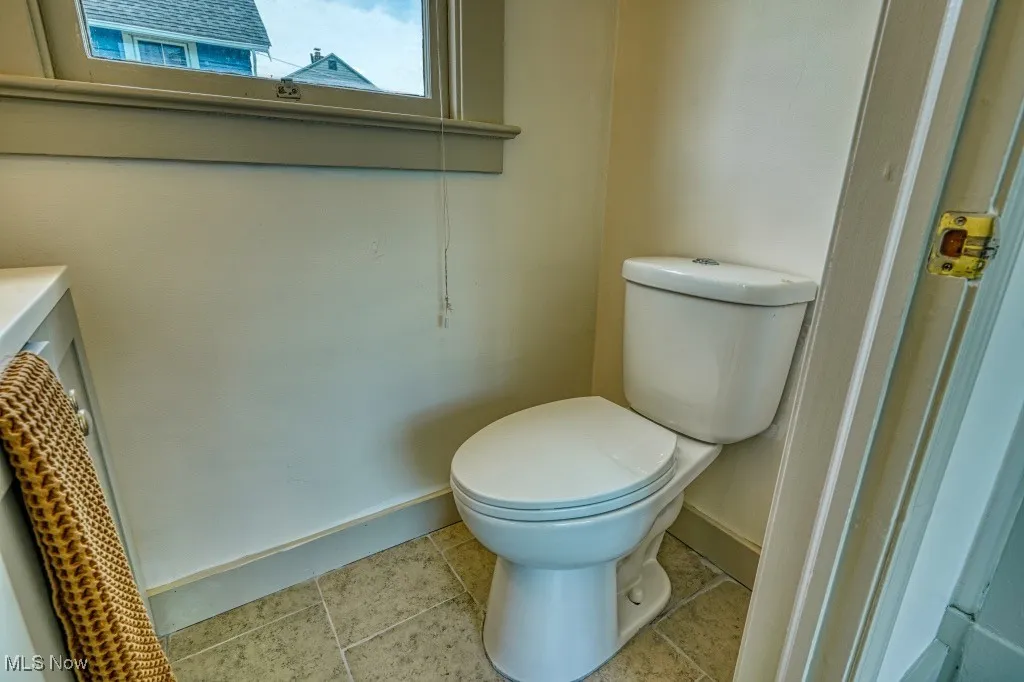 Half bathroom with baseboards and toilet