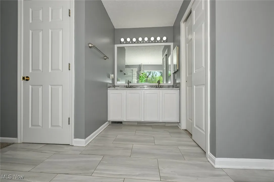 Full bath featuring vanity ,plenty of closet space, and double vanity