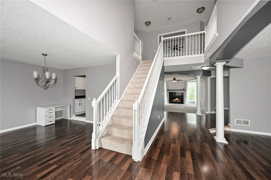 Staircase featuring new carpet, decorative columns