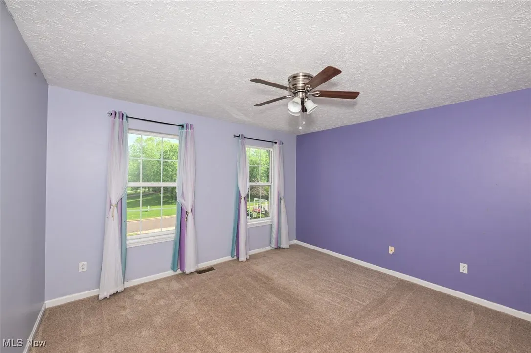 bedroom  3 featuring ceiling fan, carpet, a textured ceiling, and baseboards