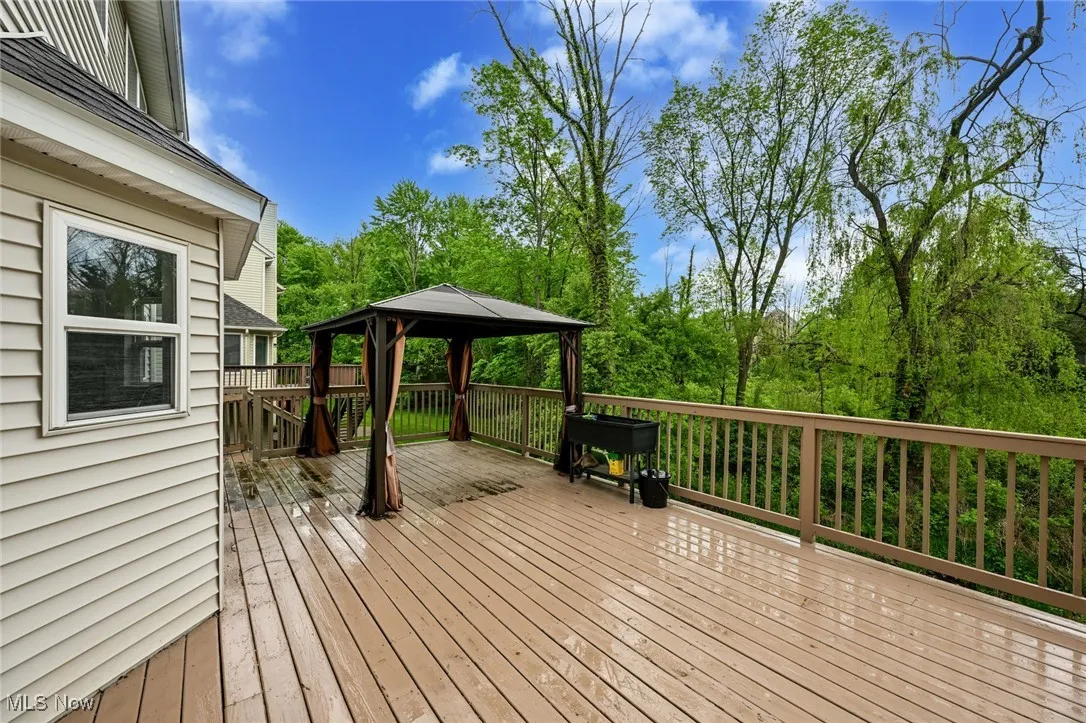 Wooden terrace with a gazebo and view of wooded area