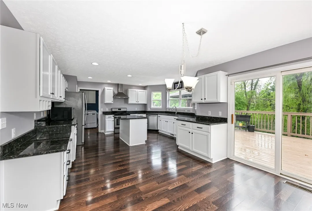 Kitchen with granite  counter tops, center island , multiple pantries. Sliding door to deck.