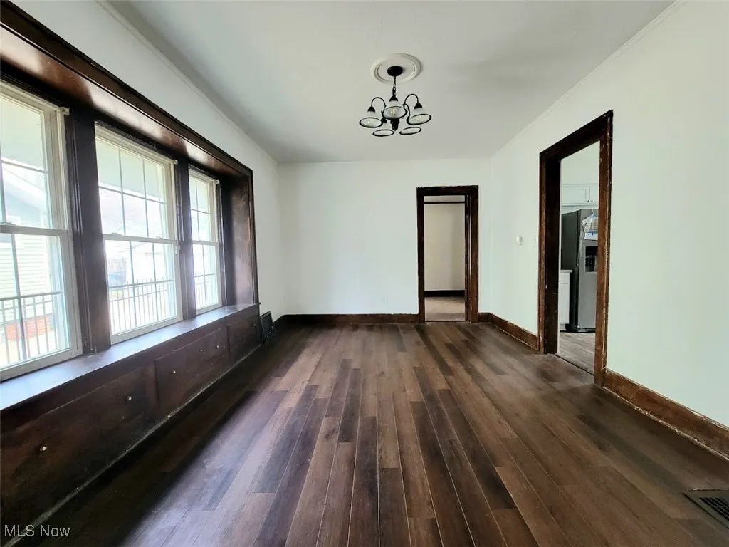 Dining room with large windows letting in natural light. Vinyl flooring.