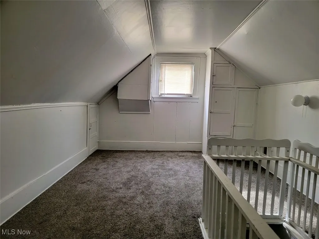Third floor attic room with carpet flooring