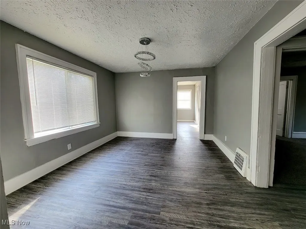 Dining room with vinyl flooring and large window that allows natural light in.