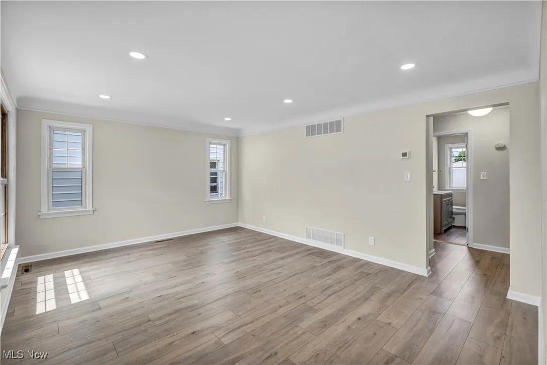 Unfurnished room featuring ornamental molding, wood finished floors, baseboards, and recessed lighting