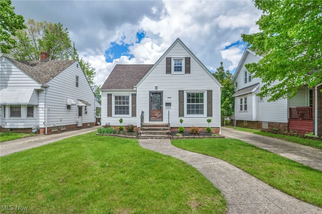 View of front of house featuring a front lawn and a shingled roof