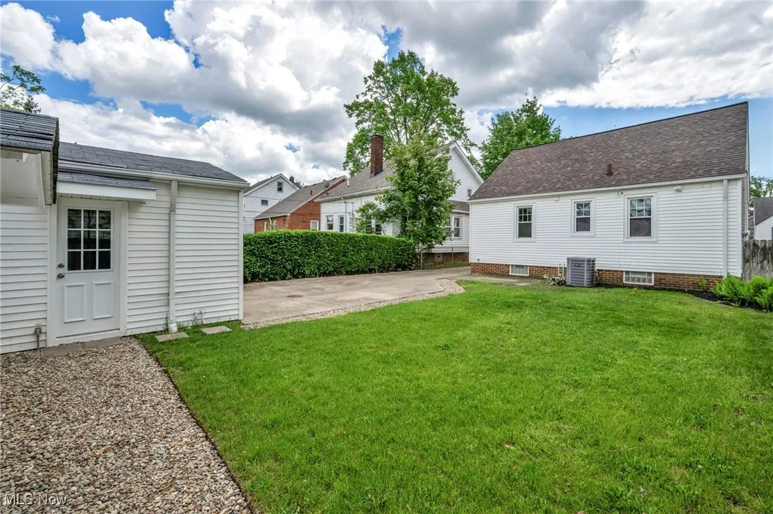 View of green lawn featuring a patio area and central AC unit