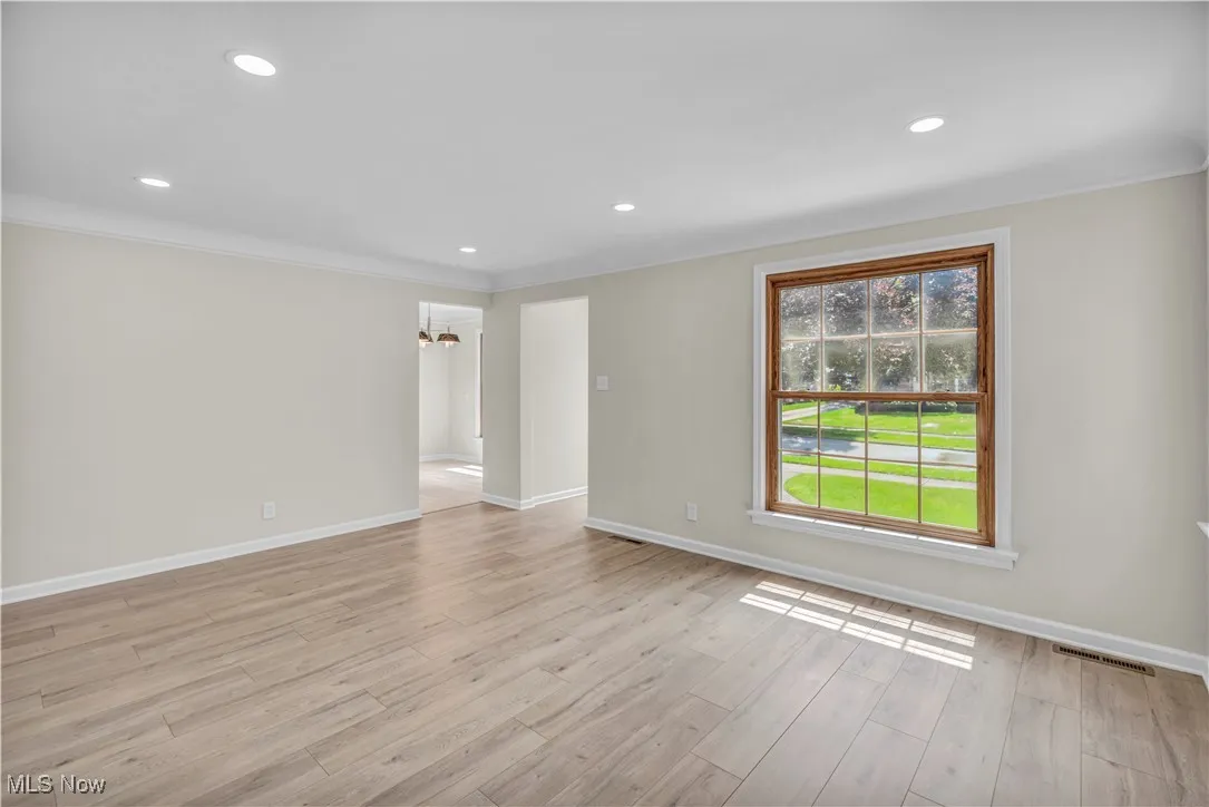 Unfurnished room featuring baseboards, ornamental molding, recessed lighting, light wood-type flooring, and a chandelier