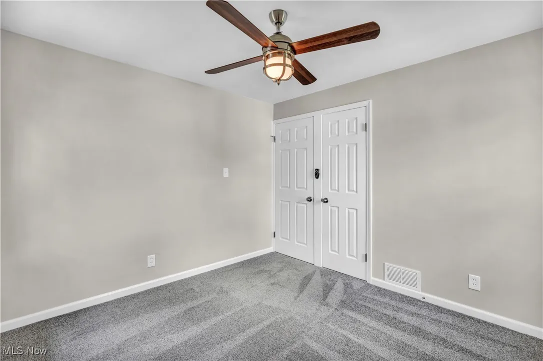 Unfurnished bedroom with baseboards, carpet flooring, ceiling fan, and a closet