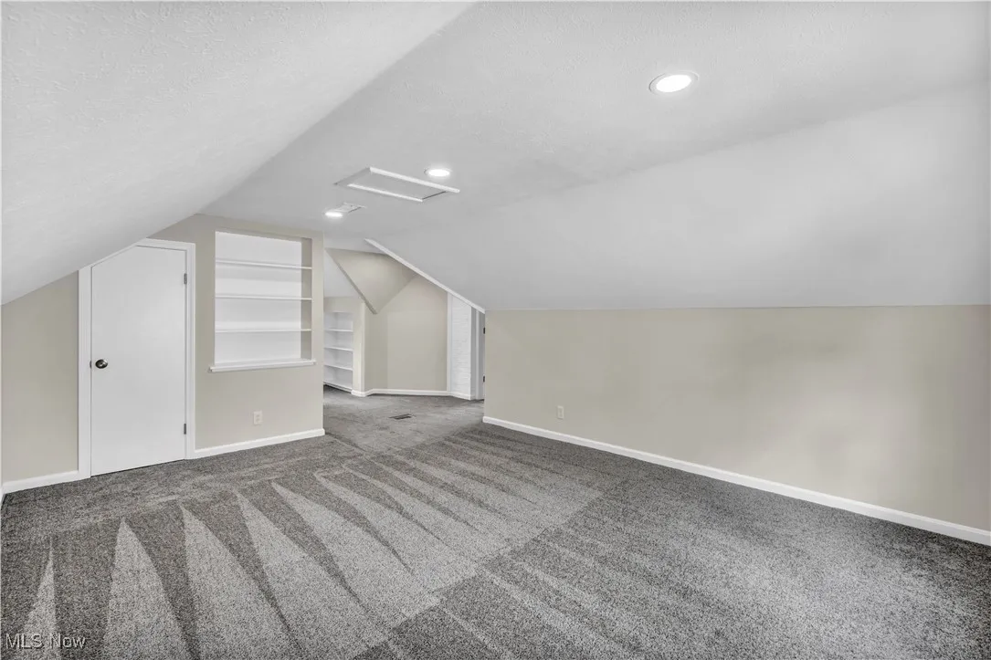 Bonus room with attic access, carpet, baseboards, vaulted ceiling, and recessed lighting