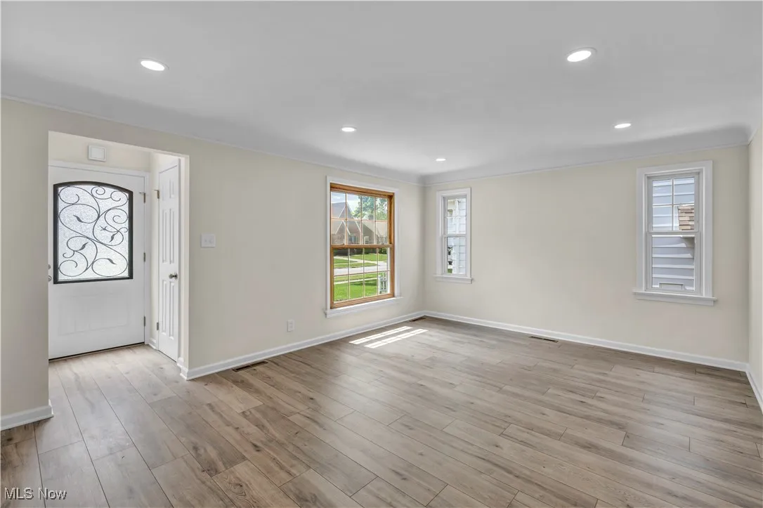 Entrance foyer with baseboards, plenty of natural light, wood finished floors, recessed lighting, and ornamental molding