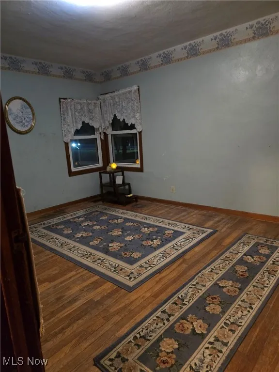 Empty room featuring wood-type flooring and baseboards