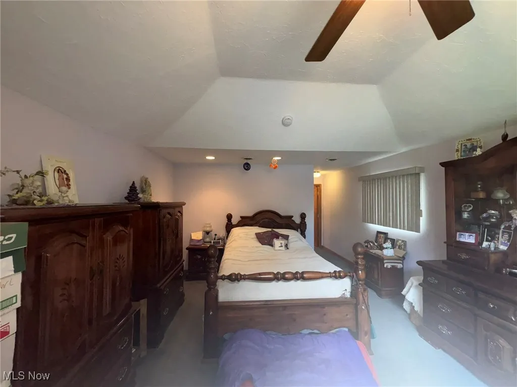Bedroom with carpet floors, lofted ceiling, and ceiling fan
