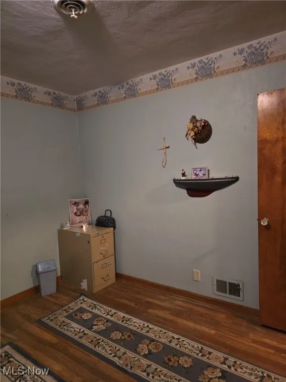 Bedroom with wood finished floors and baseboards