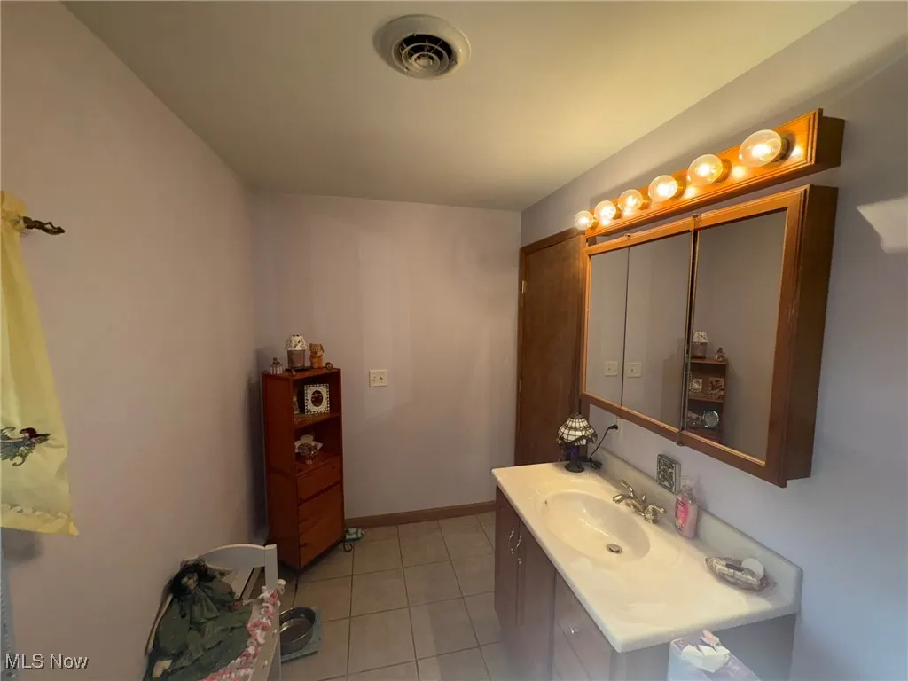 Bathroom featuring tile patterned flooring and vanity