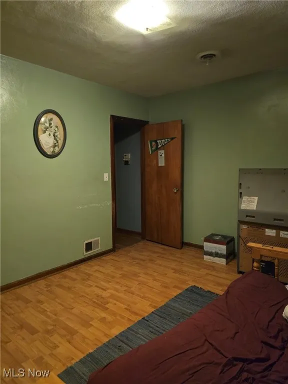 Bedroom featuring light wood finished floors and baseboards